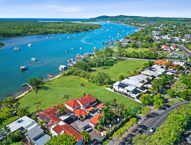 Aerial overview of Cayman Quays on the Noosa River waterfront Aerial drone view of the Noosa River looking down on the waterfront holiday apartments at Cayman Quays property in Noosaville.