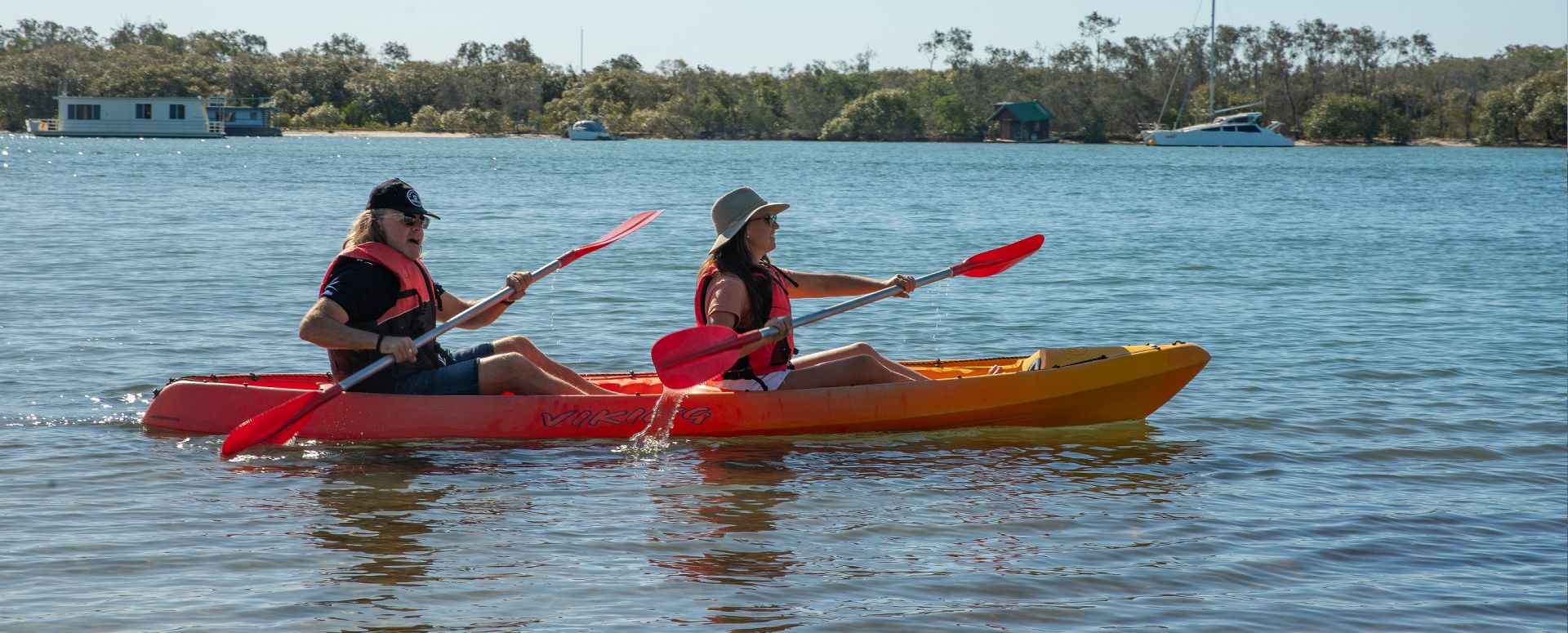 Complimentary Kayak Hire for Guests A couple using complimentary guest kayak hire to paddle along the pristine waterways of the Noosa River in Noosaville.